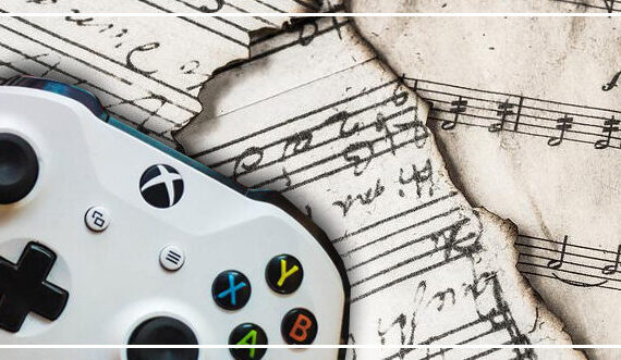 white videogame controller sitting atop torn sheet music